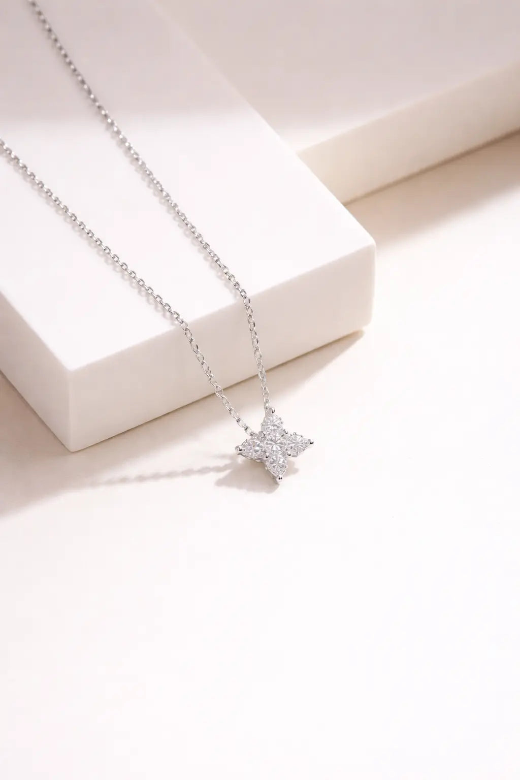 Sterling silver diamond floral cross pendant necklace on neutral background, minimalist elegant jewelry for women