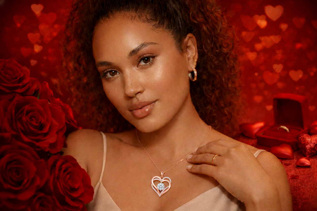 Woman wearing a heart-shaped necklace with red roses and a heart-patterned background