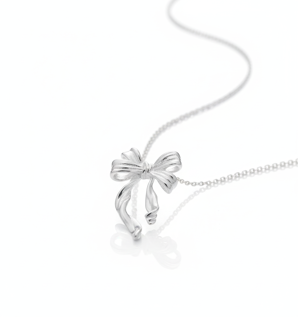 Silver bow-shaped pendant on a chain against a white background