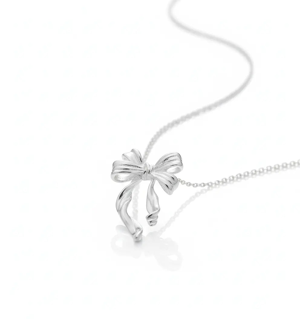 Silver bow-shaped pendant on a chain against a white background
