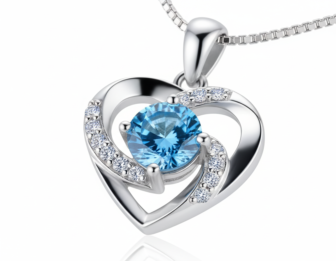 Silver heart pendant necklace with blue gemstone and crystal accents from Dione Canada displayed on a white background.