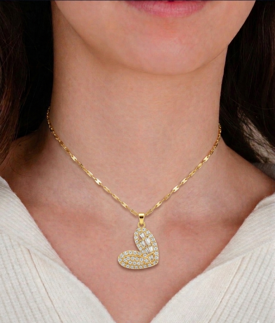 Gold necklace with a heart-shaped pendant worn by a person