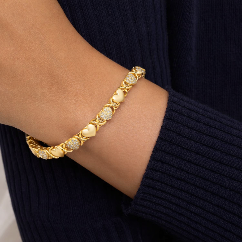 Gold heart link bracelet with diamond accents worn on wrist, elegant luxury jewelry for women