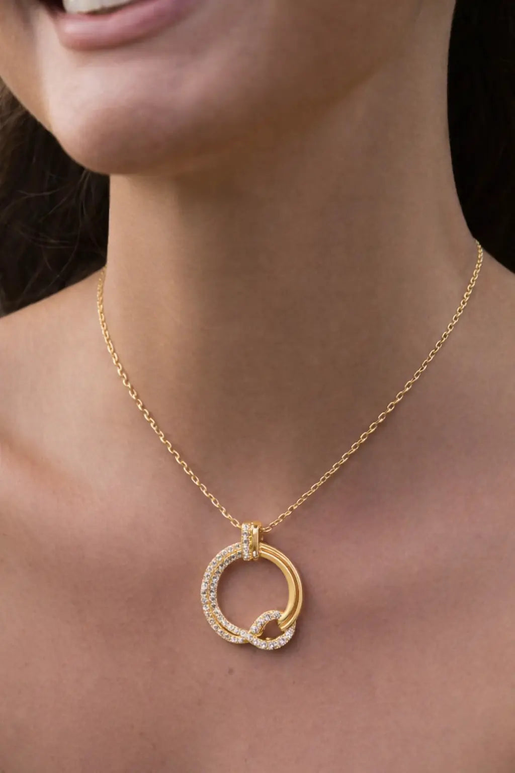 Gold interlocking circle pendant necklace with diamond accents worn on model, elegant minimalist jewelry for women