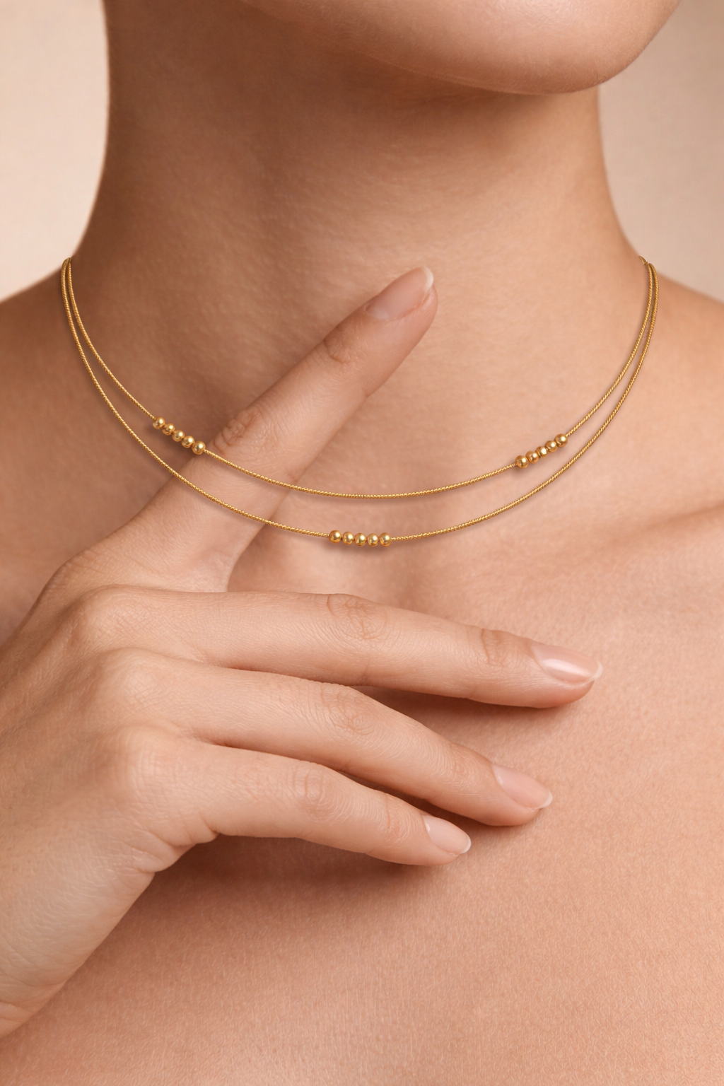 Woman wearing a layered gold beaded choker necklace in a minimal, everyday style