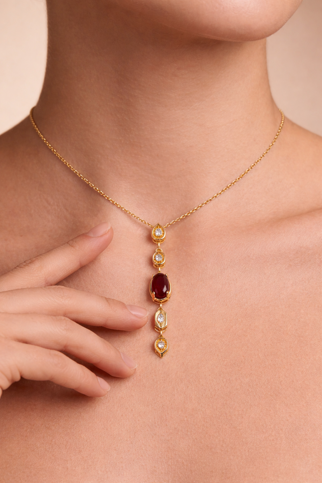 Gold necklace with red gemstone worn by a person