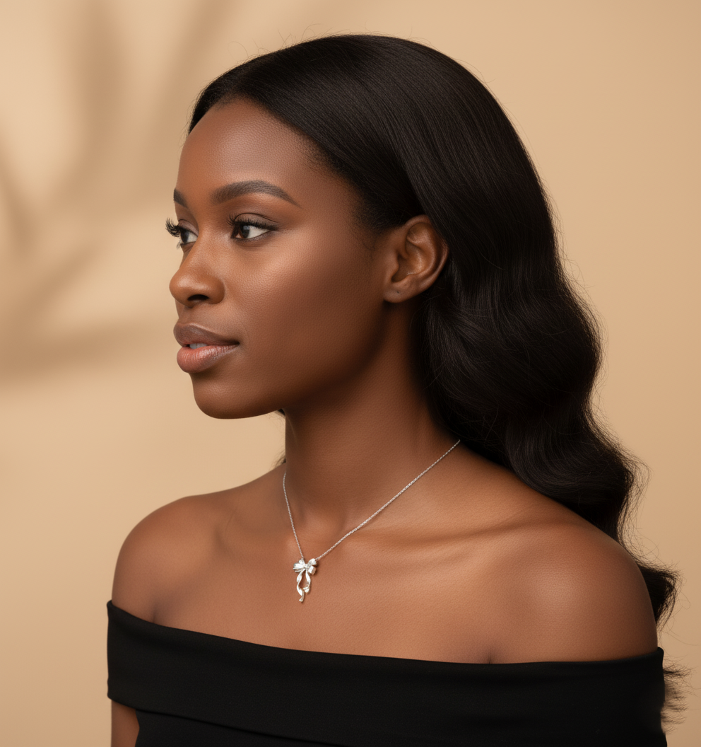 Model wearing Amoura Bow Necklace – high-polish bow knot pendant on cross-style chain in sterling silver by Dione Canada