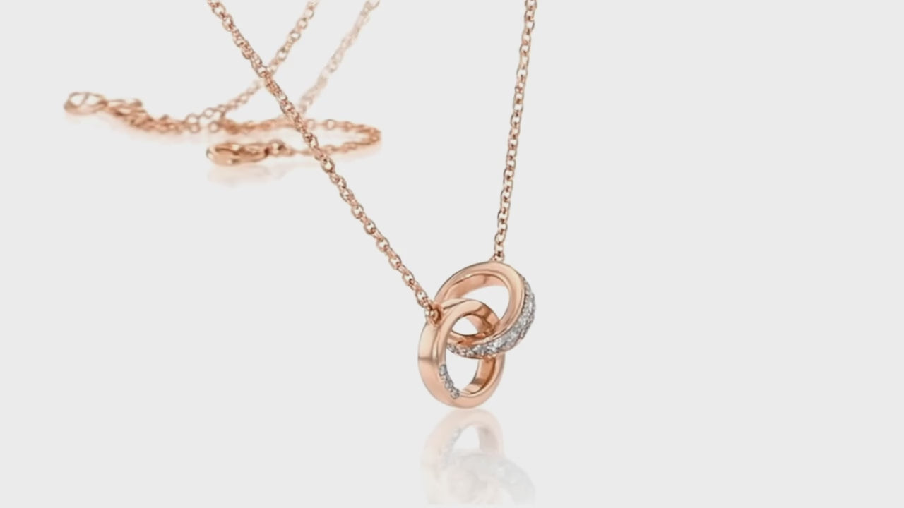 Rose gold interlocking rings necklace by Dione Canada featuring a crystal-accent band and polished minimalist design, shown in a clean luxury studio close-up.