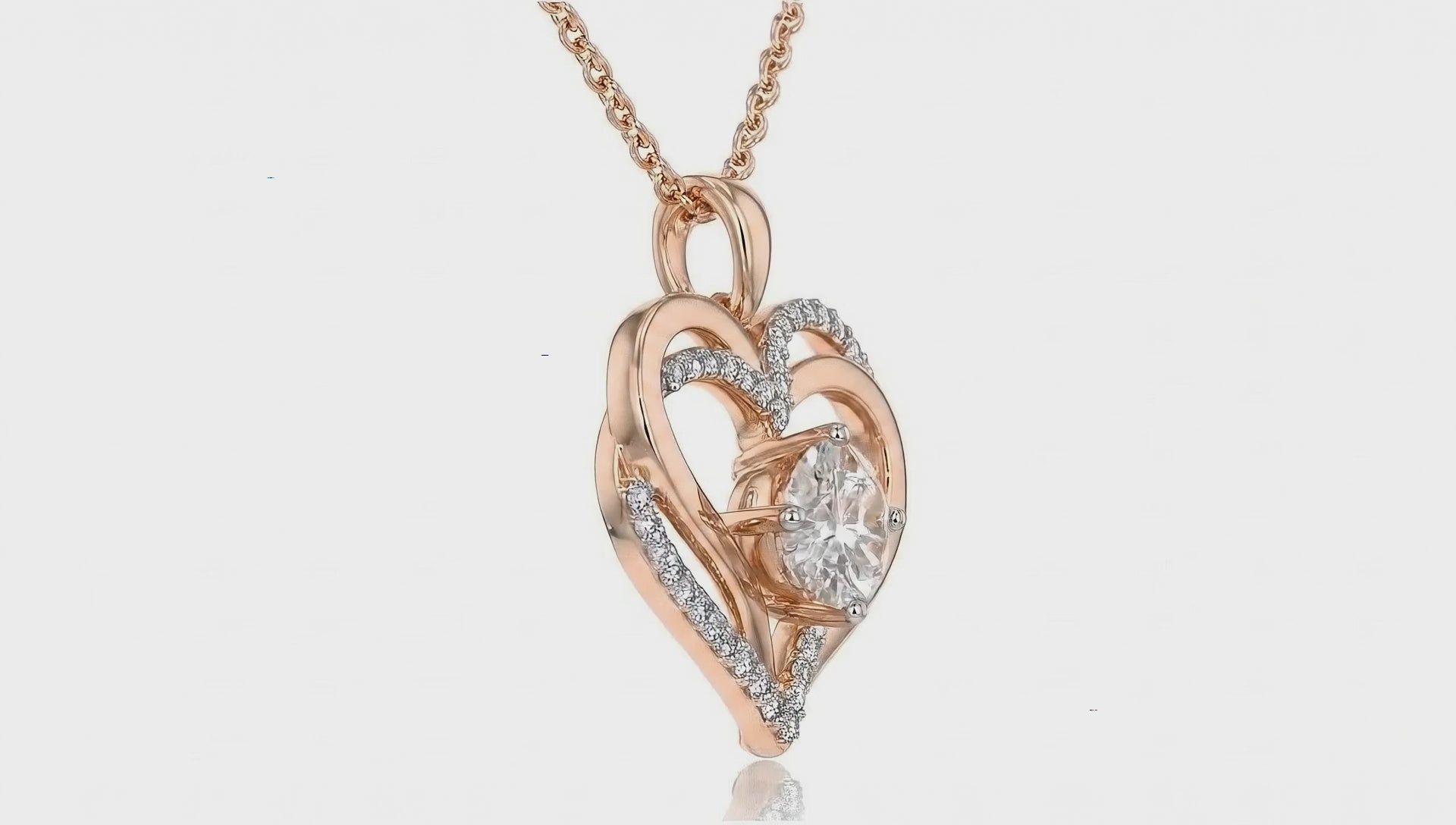 Rose gold heart pendant necklace by Dione Canada featuring a brilliant center stone and curved crystal-accent details, shown in a clean luxury studio close-up.