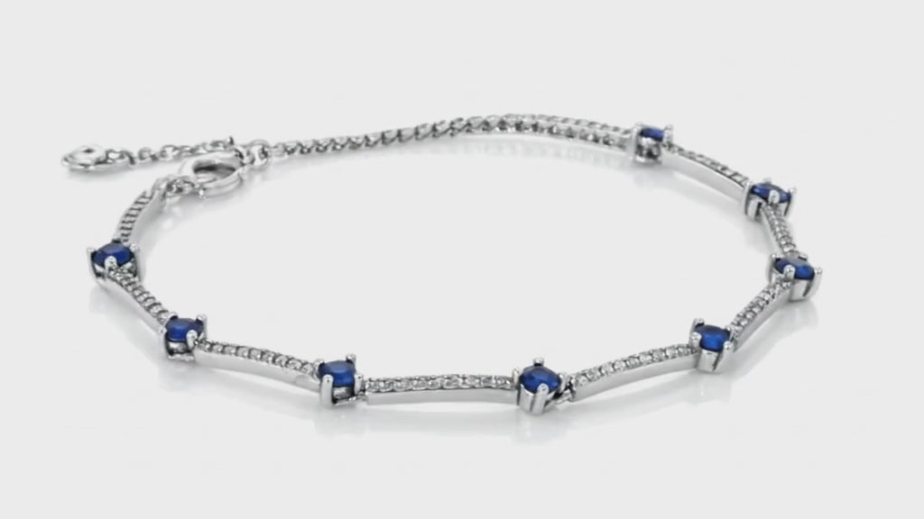 Silver bracelet with blue sapphire accents and shimmering stone detailing by Dione Canada, elegant luxury studio close-up.