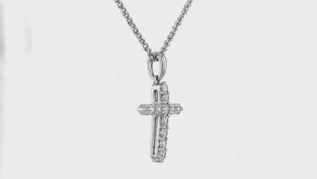 Silver crystal cross pendant necklace by Dione Canada featuring a polished design with shimmering stone accents, shown in a clean luxury studio close-up.