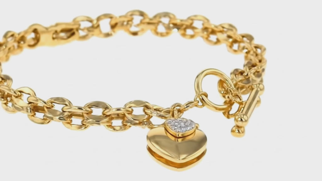 Gold heart link toggle bracelet by Dione Canada featuring a polished chain design and crystal-accent heart charm, luxury studio close-up.