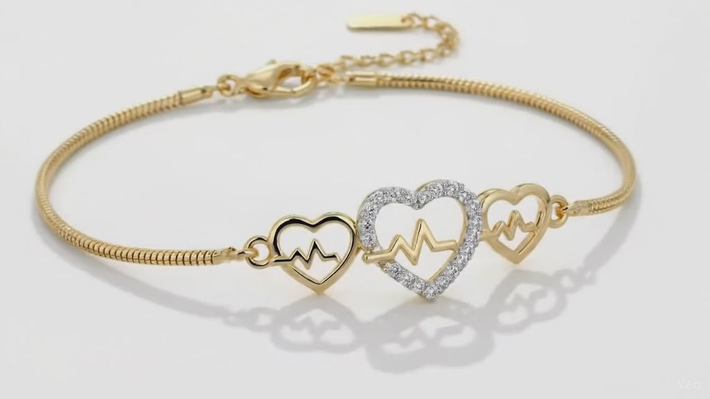 Heartbeat charm gold bracelet by Dione Canada featuring triple heart design with pavé detailing, luxury studio close-up.