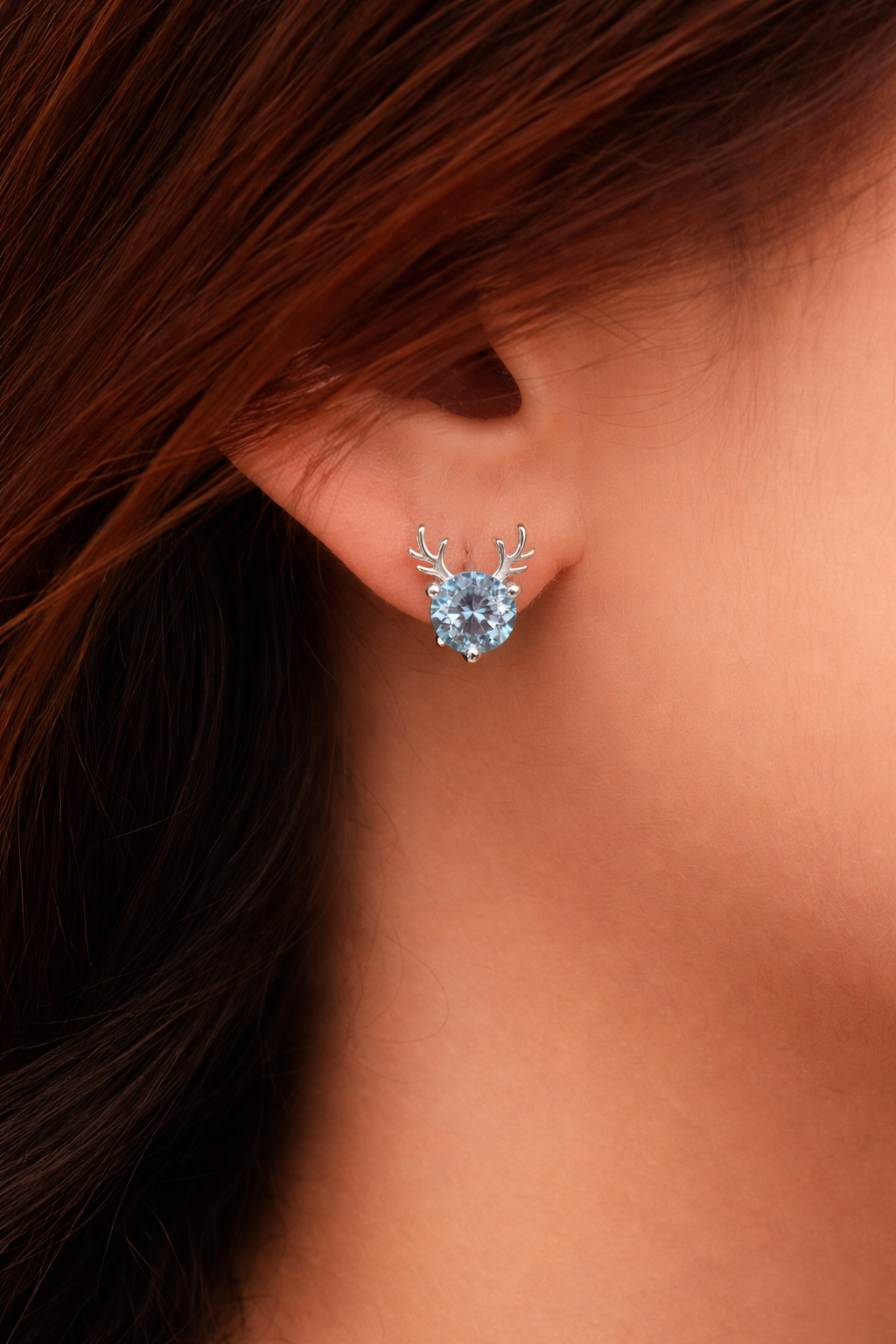 Sterling silver deer antler stud earrings with blue stone worn on ear, unique minimalist jewelry for women