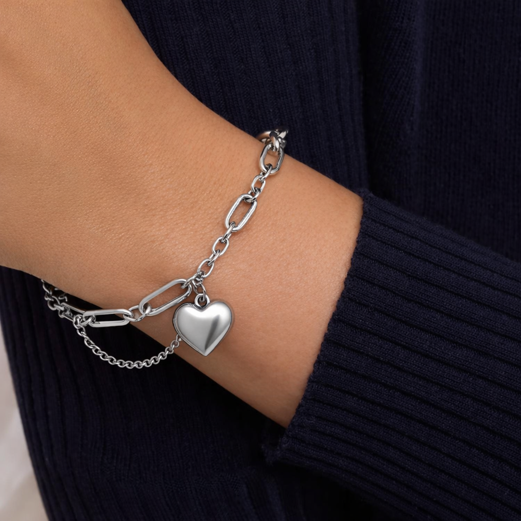 Sterling silver paperclip chain bracelet with heart charm worn on wrist, modern minimalist jewelry for women
